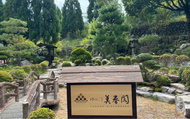 ホテル湯の杜美春閣の日本庭園と入口の看板