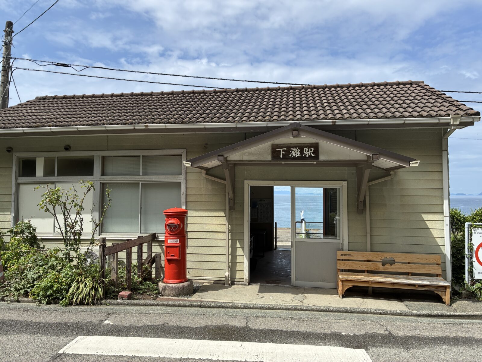 下灘駅の駅舎と赤い丸ポスト、木のベンチ